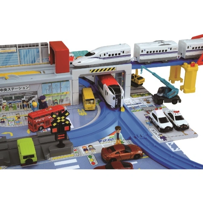  Toy train set with trains, cars, station, and crane, creating a miniature cityscape.
